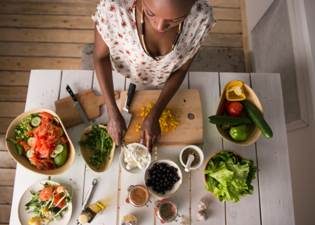 Aerial view of Black woman making a salad.