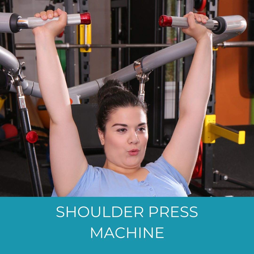 woman in blue using shoulder press machine at the gym